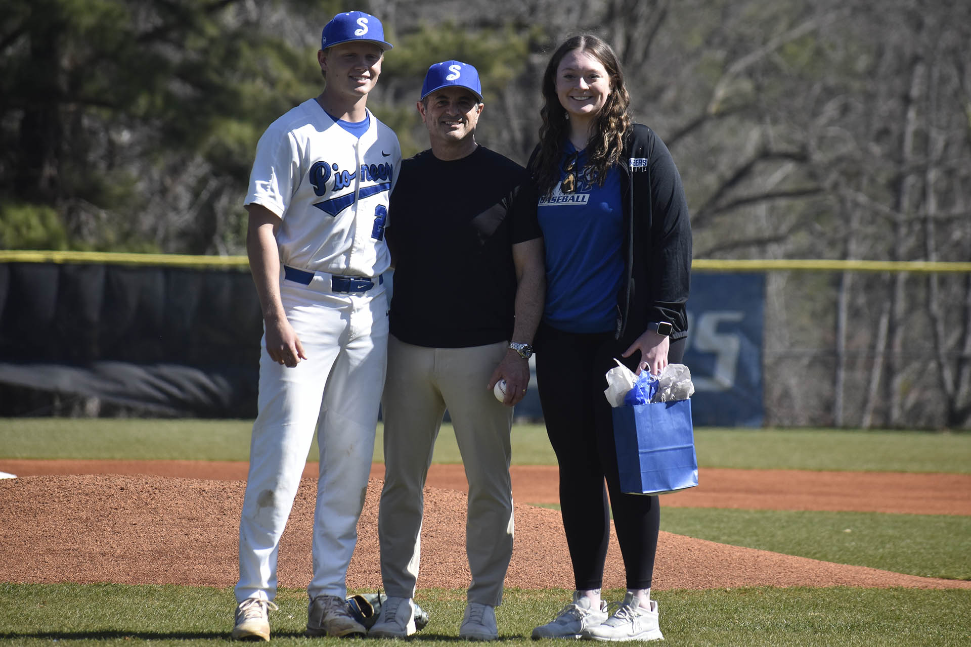 SMC President Scott Cochran (center) throws out the ceremonial first pitch prior to SMC&rsquo;s baseball doubleheader against Johnson. Photo by Danny Kambel, SMC Sports Communications.